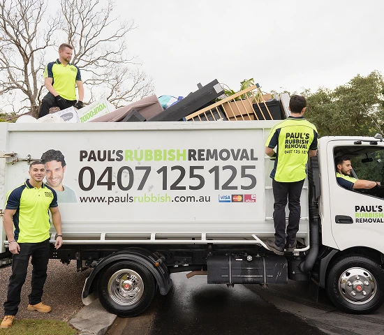The crew standing with their fully loaded rubbish removal truck
