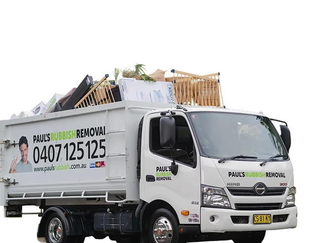 A rubbish removal truck loaded high on a suburban street